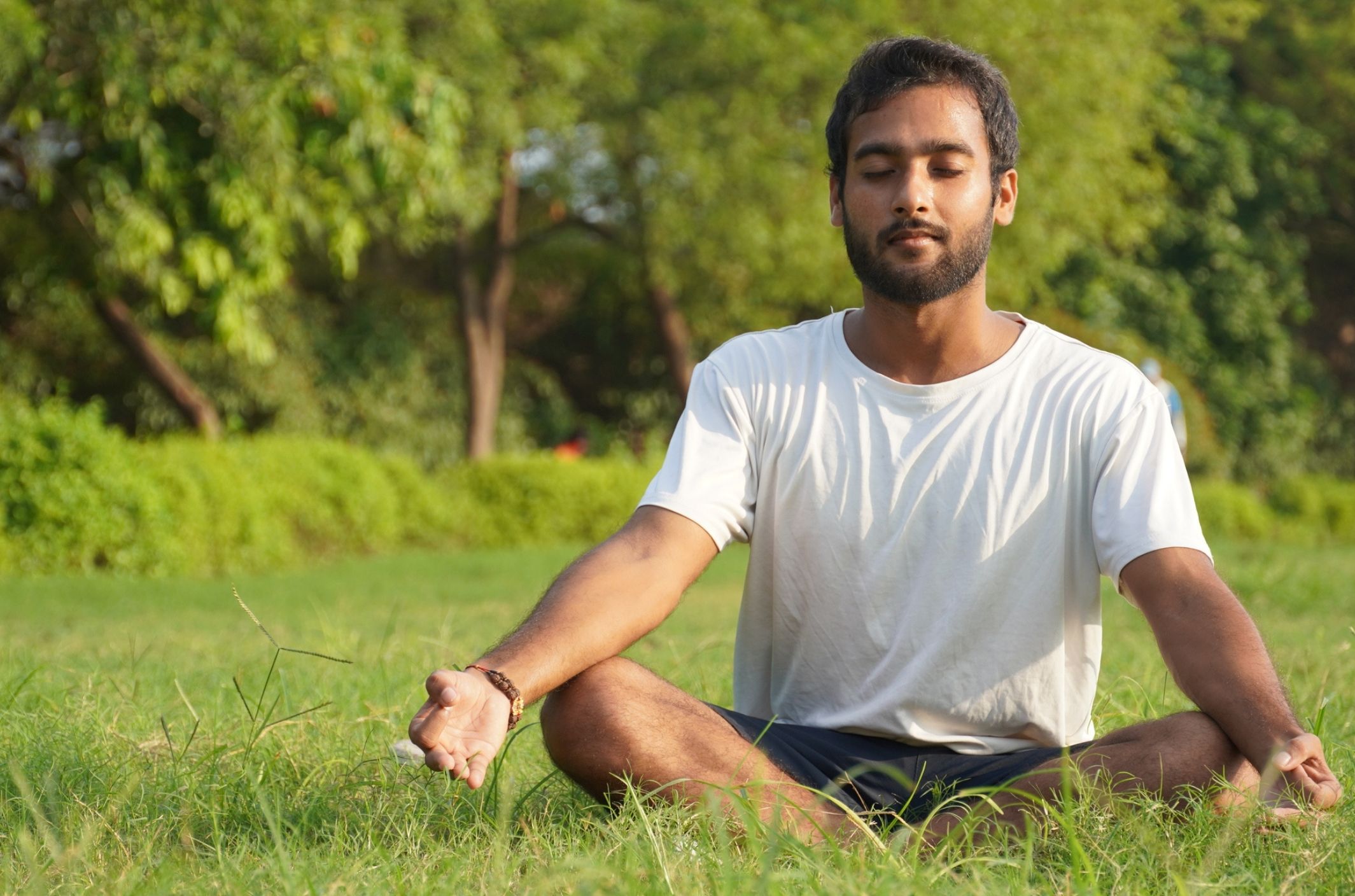 young man practicing distress tolerance meditation skills in field