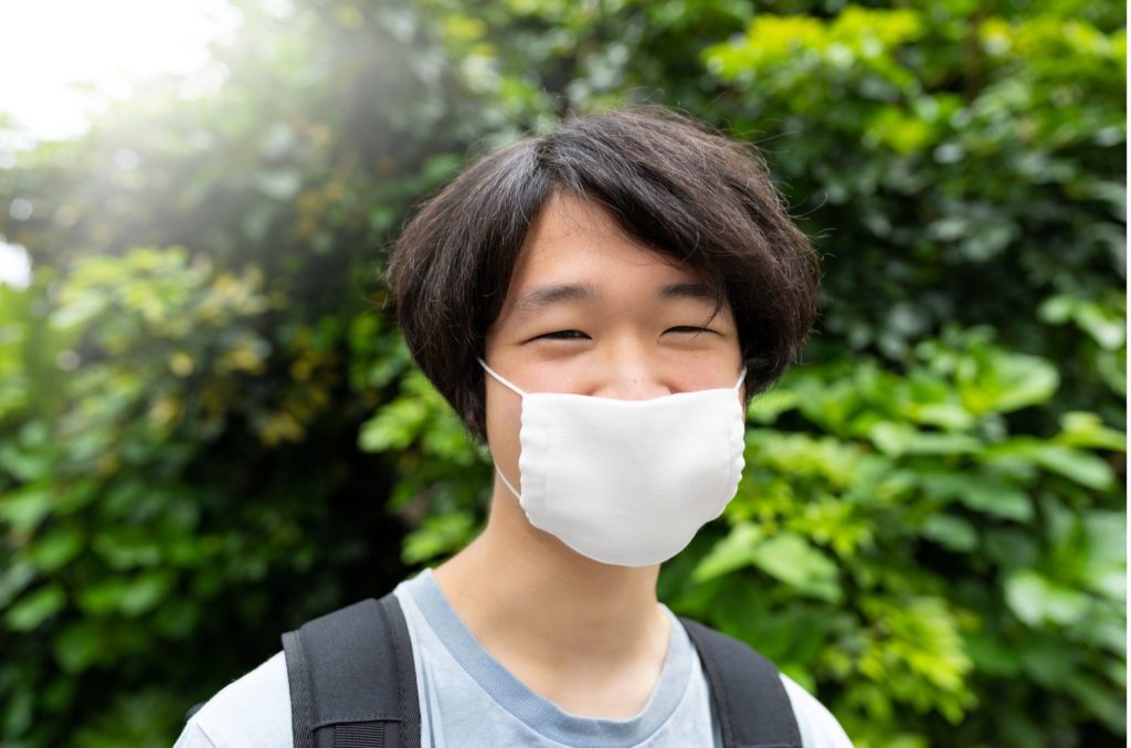 young man wearing mask during covid pandemic and avoiding depression