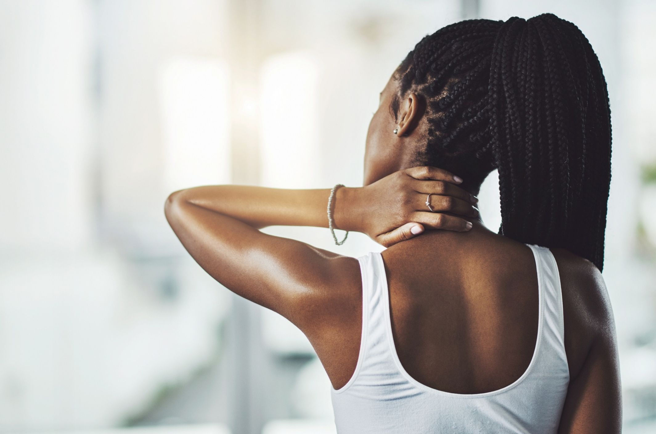 young woman with physical symptoms of depression touching neck