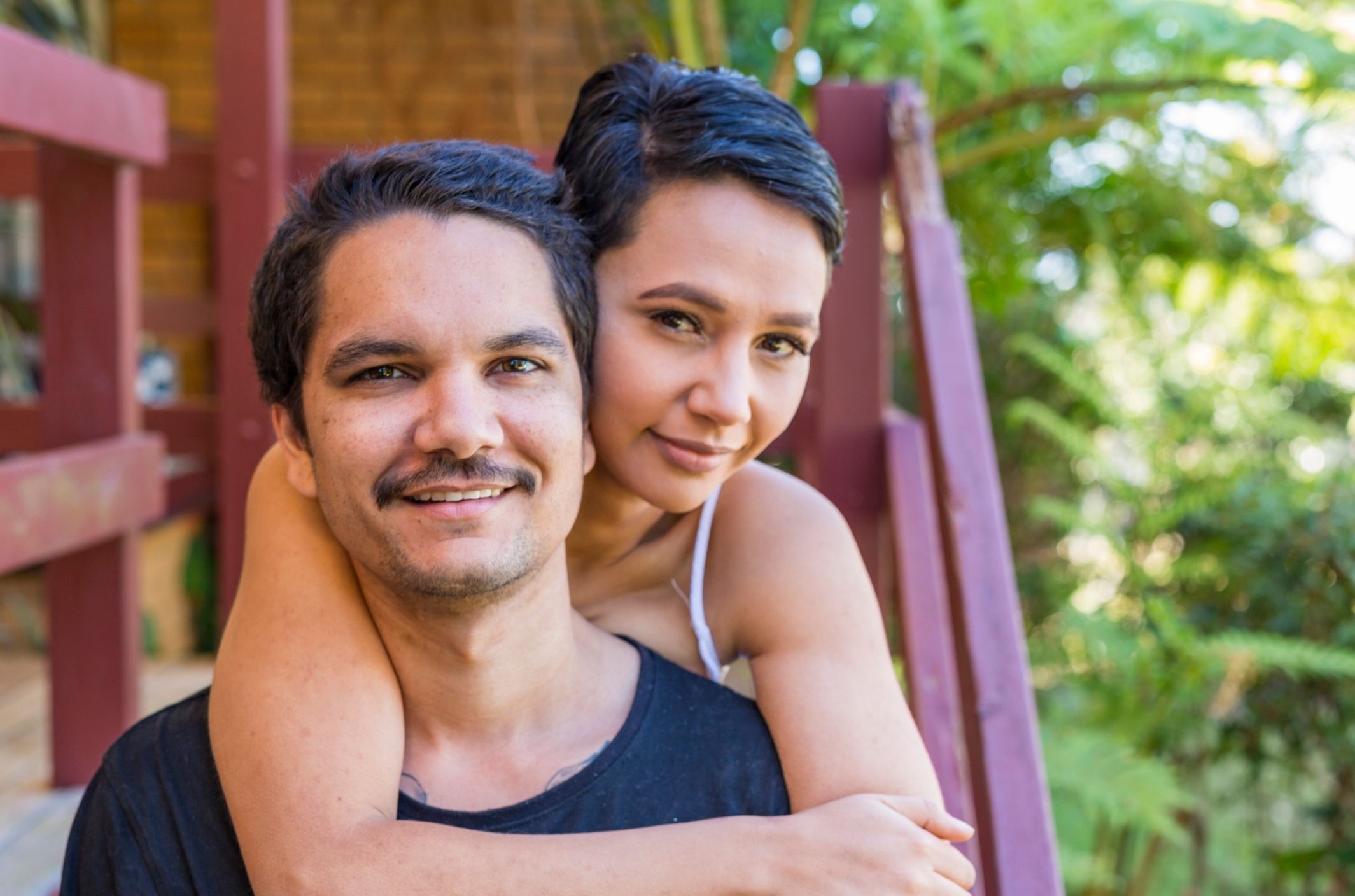 couple embracing smiling on porch after dealing with erectile dysfunction in their relationship