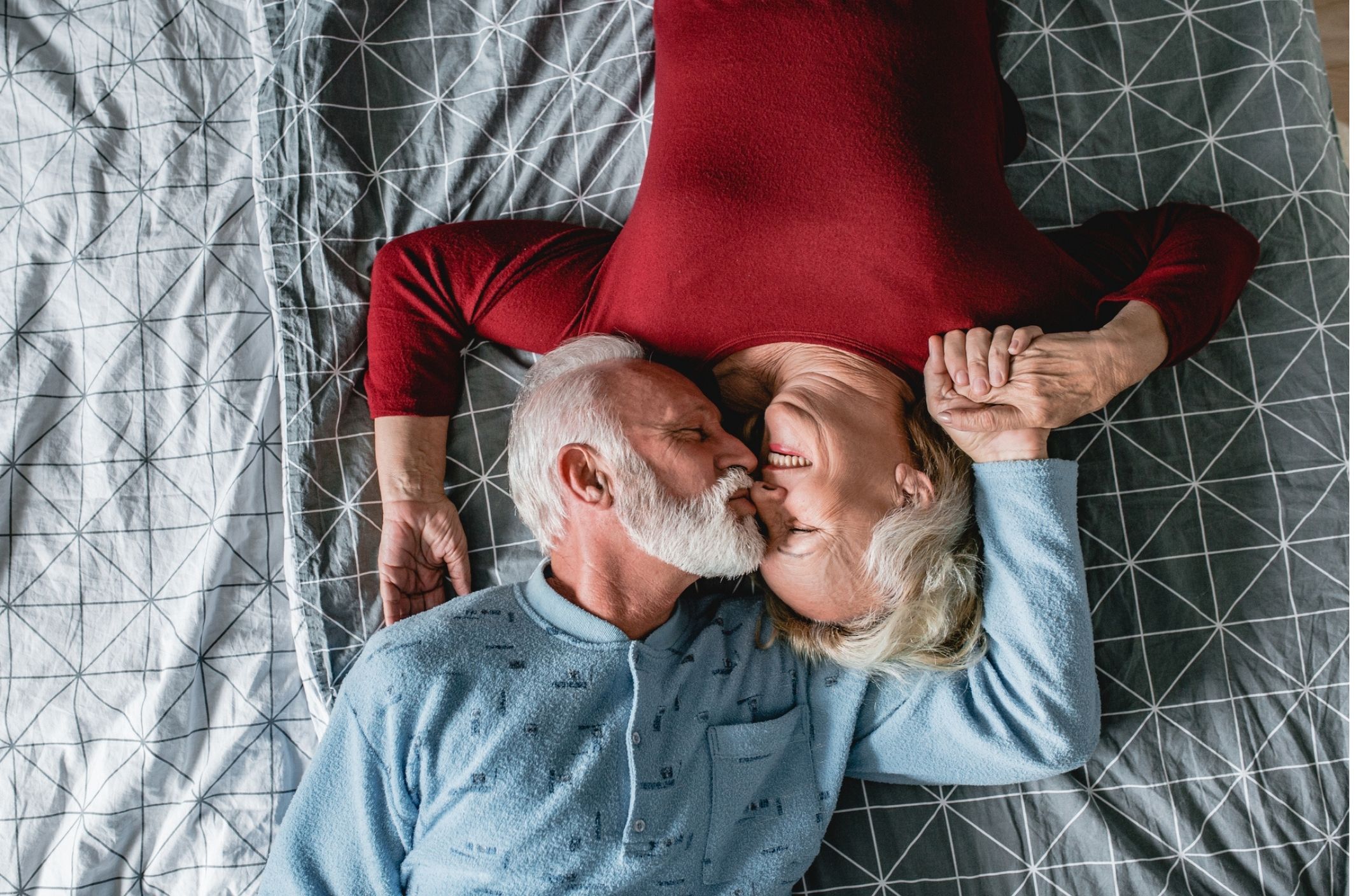 older couple in bed smiling embrace after learning about erectile dysfunction ed and age