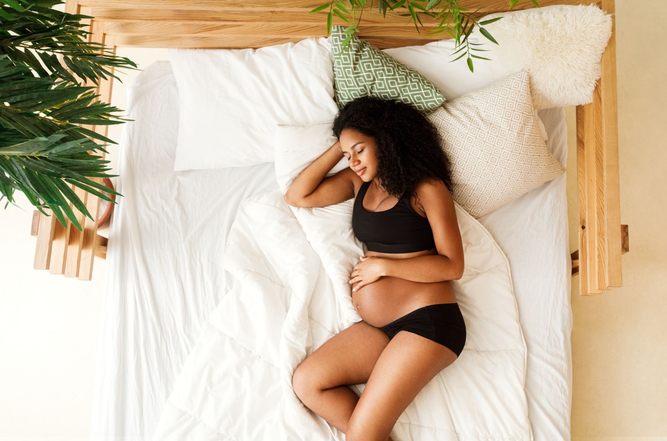 pregnant woman in bed resting in bed after treating pregnancy insomnia