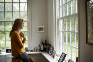 Image of a woman looking out a window considering birth control options