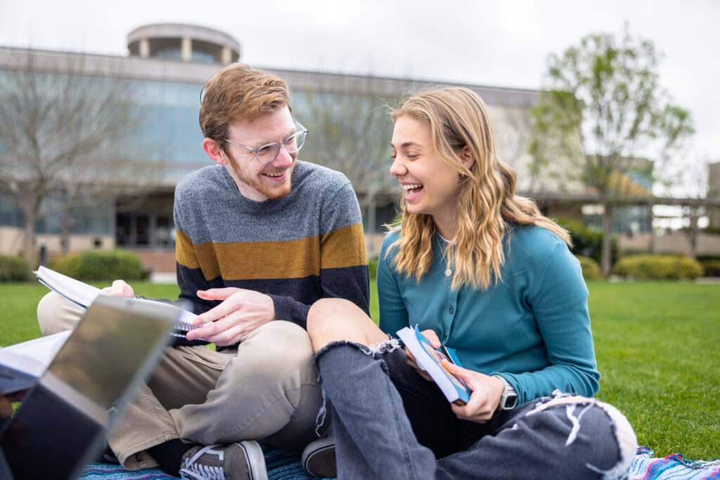 Man and Woman researching outside on the lawn.