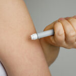 Close-up of a woman’s hand holding a self-injection pen, symbolizing the administration of GLP-1 medications.