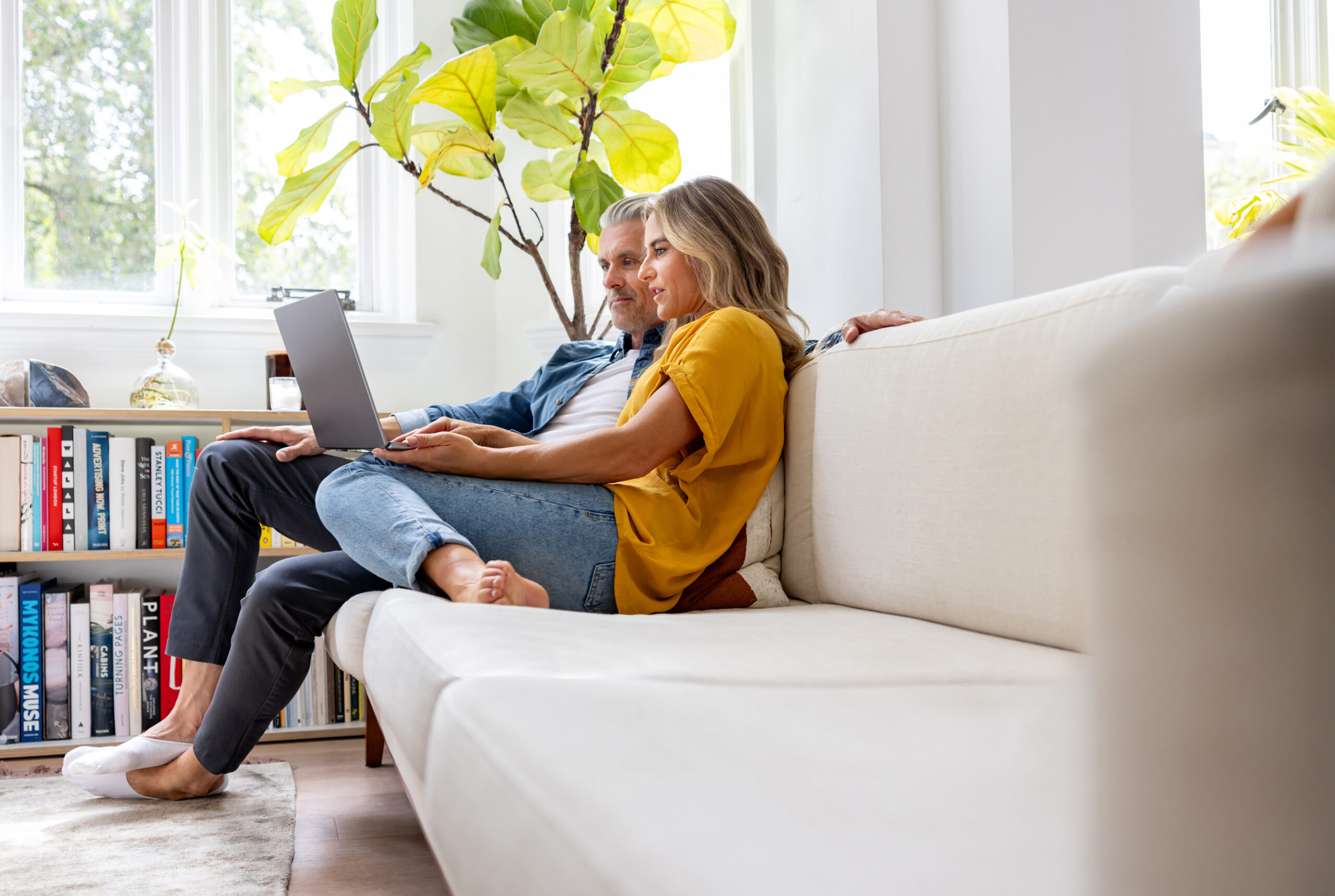 A couple at home using a laptop, researching information on erectile dysfunction and its impact on relationships.