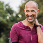 A man with thinning hair exercising outside, contemplating his hair loss treatment options, such as finasteride and minoxidil, while considering the best approach for effective results.