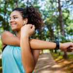 A woman stretching on a sidewalk before a run, symbolizing an active lifestyle and heart health, reflecting the importance of understanding cholesterol for overall well-being.