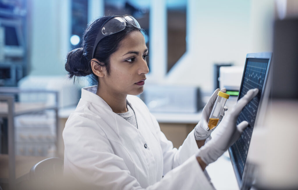 A female scientist in a laboratory, reviewing data on a computer screen, symbolizing the latest advancements in cholesterol research and personalized health management