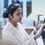 A female scientist in a laboratory, reviewing data on a computer screen, symbolizing the latest advancements in cholesterol research and personalized health management