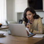 A woman researching birth control options on her laptop, comparing different choices to determine which one is the best fit for her health and lifestyle.