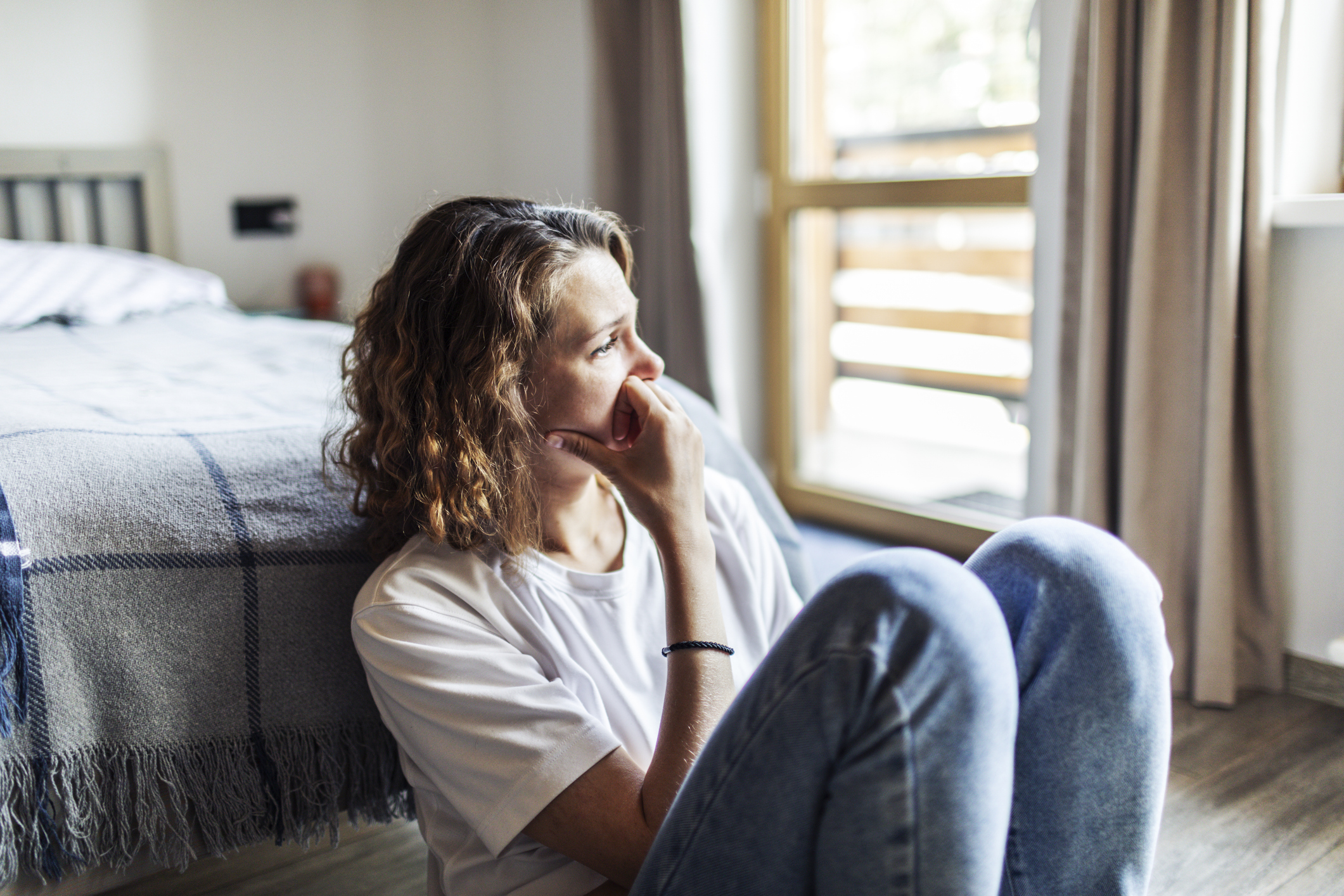 A woman sitting with her head in her hands, expressing stress and emotional distress, symbolizing the mental health struggles related to anxiety and depression.