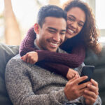 Couple reviewing Viagra® information on a cellphone together, highlighting the importance of discussing usage, dosage, and lifestyle adjustments for optimal effectiveness.