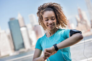 Woman tracking her workout progress on a fitness app, highlighting the importance of tracking metrics to stay motivated on a weight loss journey.