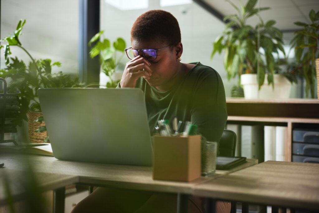 Businesswoman with a headache, representing the potential challenges and symptoms when stopping Zoloft® abruptly.