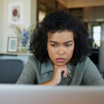 Woman researching on her laptop to understand the effects of taking two birth control pills.