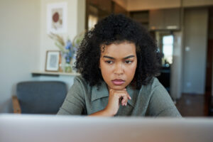 Woman researching on her laptop to compare the benefits, side effects, and suitability of Zoloft®, Prozac®, Lexapro®, and Wellbutrin® for managing depression and anxiety.