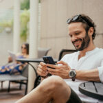 Man researching on his phone while relaxing by the pool, emphasizing the importance of understanding the guidelines for alcohol consumption when taking medications like Stendra® to ensure safety.