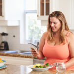 Woman enjoying a healthy meal, reflecting the importance of a balanced diet and lifestyle changes in supporting weight loss efforts, alongside the the role of supplements in a weight management plan.