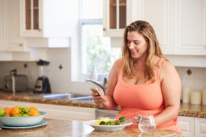 Woman enjoying a healthy meal, reflecting the importance of a balanced diet and lifestyle changes in supporting weight loss efforts, alongside the the role of supplements in a weight management plan.